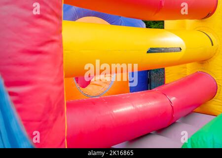 Particolare di un castello gonfiabile dai colori vivaci, vuoto senza bambini. Foto Stock