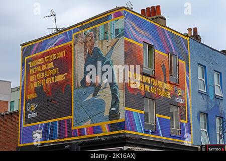 Da soli sei duro, insieme siamo più duri. Dr Martens costruzione murale arte, su un negozio a Camden High Street, Camden Town, Londra, Inghilterra, UK, NW1 Foto Stock