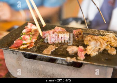 Tagliare a dadini il manzo e il vitello a strisce in padella e stufa, fuoco selettivo Foto Stock