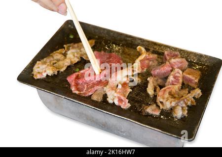 Tagliare a dadini il manzo e il vitello striato sulla padella e stufa su bianco isolato. Foto Stock