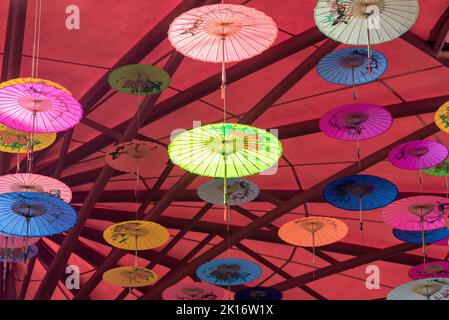 Colorati ombrelli di olio-carta appesi nell'aria Foto Stock