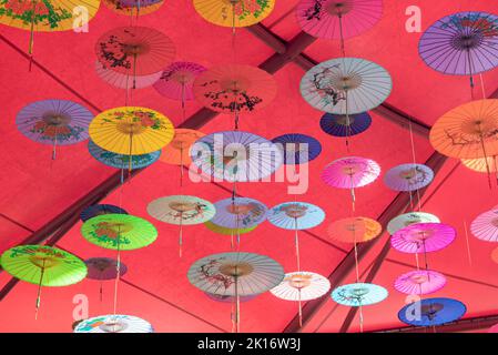 Colorati ombrelli di olio-carta appesi nell'aria Foto Stock