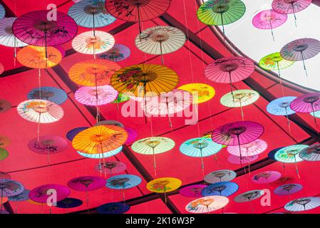 Colorati ombrelli di olio-carta appesi nell'aria Foto Stock