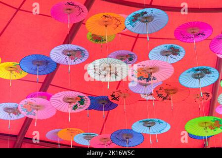 Colorati ombrelli di olio-carta appesi nell'aria Foto Stock