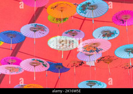 Colorati ombrelli di olio-carta appesi nell'aria Foto Stock