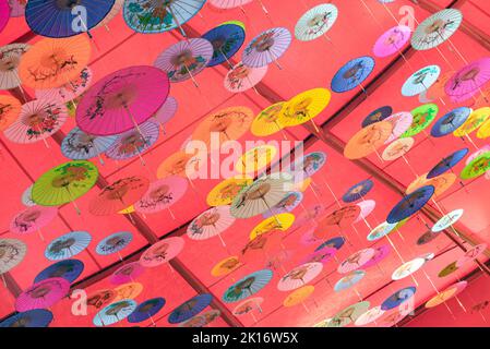 Colorati ombrelli di olio-carta appesi nell'aria Foto Stock