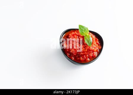 Ajika isolato su sfondo bianco. Salsa calda Foto Stock