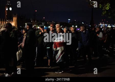 I membri del pubblico in coda alle 03:47 del Thames Path di fronte al Palazzo di Westminster a Londra, mentre attendono di vedere la regina Elisabetta II stesa in stato davanti al suo funerale di lunedì. Data immagine: Venerdì 16 settembre 2022. Foto Stock