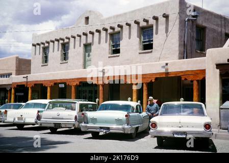 Auto parcheggiate sulla strada fuori dall'ufficio di Sheriff, si pensa che sia Taos, New Mexio, USA 1963 Foto Stock