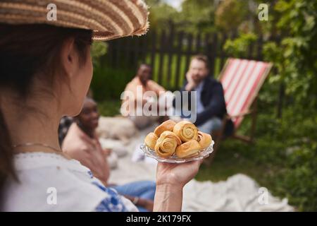 Donna che tiene piatto con dolci Foto Stock