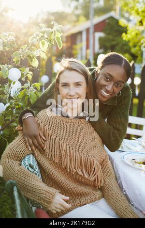 Amici femminili seduti al tavolo Foto Stock