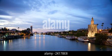 Vista notturna panoramica del fiume Guadalquivir a Siviglia. Foto Stock