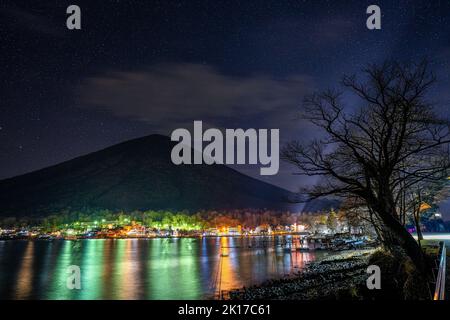 Una vista panoramica del Monte Nantai e degli edifici costieri con luci illuminate a Nikko Foto Stock