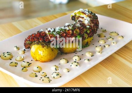 Coscia di polpo galiziano grigliata con patate arrosto e aioli all'aglio Foto Stock