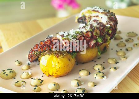 Coscia di polpo galiziano grigliata con patate arrosto e aioli all'aglio Foto Stock