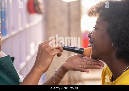 signora africana che fa il trucco per una signora Foto Stock