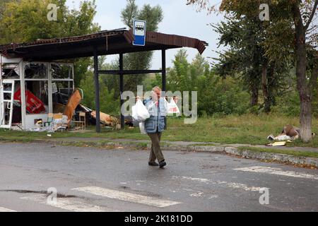 IZIUM, UCRAINA - 15 SETTEMBRE 2022 - Un uomo trasporta i sacchetti con l'aiuto umanitario a Izium che è stato liberato dagli invasori russi, regione di Kharkiv, Foto Stock