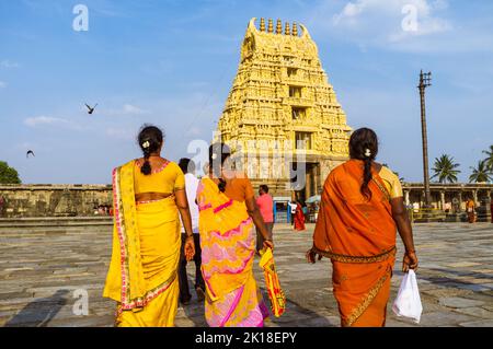 Belur, Karnataka, India: Tre donne in sari colorati camminano verso la porta gopuram del Tempio di Chanchakeshava del 12th ° secolo. Foto Stock