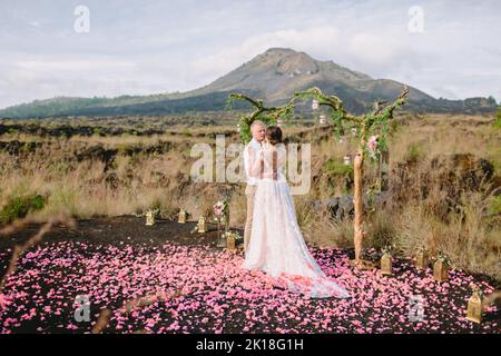 Febbraio 14, 2021. Bali, Indonesia. Giorno di nozze con coppia elegante in montagna. Cerimonia con arco e coppia appena sposata Foto Stock