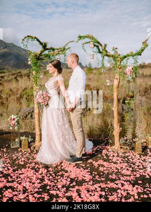 Febbraio 14, 2021. Bali, Indonesia. Giorno di nozze con coppia elegante in montagna. Cerimonia con arco e coppia appena sposata Foto Stock