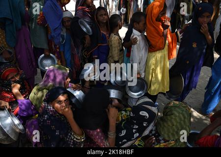 Le persone colpite dalle inondazioni ricevono acqua nelle aree inondate di Sehwan Sindh Pakistan Foto Stock