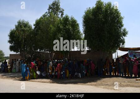 Le persone colpite dalle inondazioni ricevono acqua nelle aree inondate di Sehwan Sindh Pakistan Foto Stock