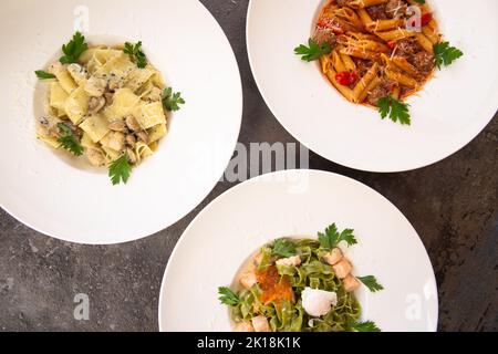 tre di pasta su sfondo grigio, vista dall'alto Foto Stock