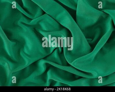 Uno sfondo di tessuto verde stropicciato. Primo piano. Foto Stock
