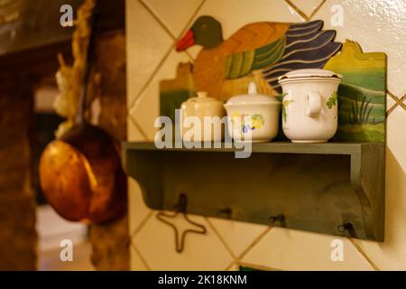 Utensili da cucina classici e antichi, ripiani con canister per cibi e spezie. Foto Stock
