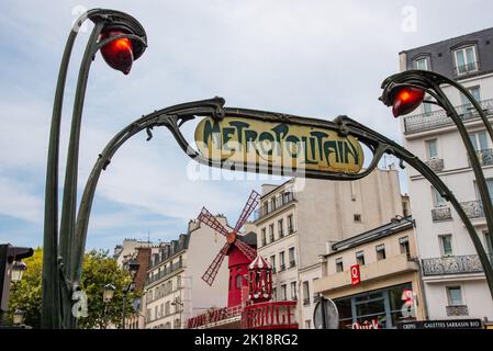 Parigi, Francia. Agosto 2022. Il caratteristico segno metropolitano con il Moulin Rouge sullo sfondo. Foto di alta qualità Foto Stock