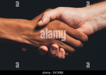 Le vite nere contano. Tolleranza umana. Closeup multicolor mani maschili che scuotono isolato al buio. Amicizia etnica. Accordo sulle gare. Nessun razzismo. sostegno alla pace Foto Stock