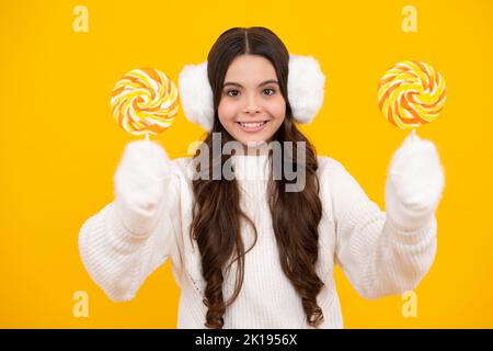 Ragazza adolescente con caramelle al caramello su bastoni, zucchero dolce dipendenza. Bambino con lecca-lecca. Faccia felice, emozioni positive e sorridenti della ragazza adolescente. Foto Stock