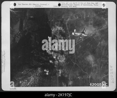 Un Liberatore B-24 consolidato del 15th AF lascia il Target a Monaco, in Germania, oscurato da Smoke. Foto Stock