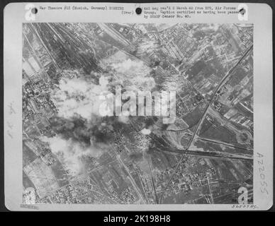 Le bombe che esplodono inviano spruzzi di detriti mentre prendono il pedaggio sui cantieri di marshalling ferroviario a Monaco di Baviera, Germania, 25 febbraio 45. L'occasione è stata l'attacco di luce del giorno su larga scala da parte di US 8th AF pesanti bombardieri su installazioni ferroviarie, basi aeree, e obiettivi petroliferi. Foto Stock