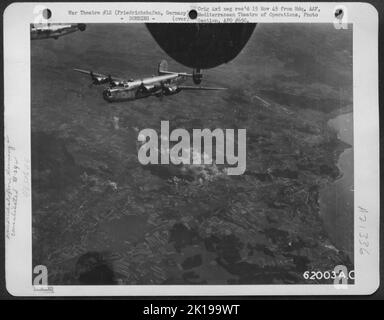 La bomba scoppia sul bersaglio a Friedrichshafen, Germania, come Consolidated B-24 Liberator of the 15th AF diventa Homeward. 16 agosto 1944. Foto Stock
