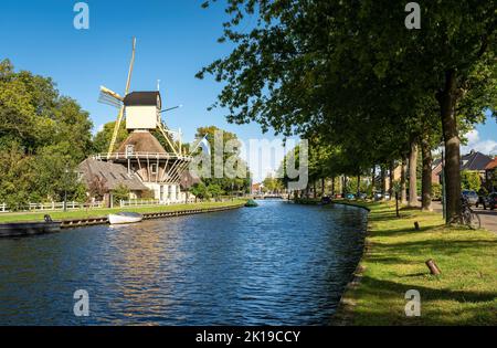 Storico mulino a vento olandese in legno lungo il canale nella città di Weesp, provincia Nord Olanda, Paesi Bassi Foto Stock