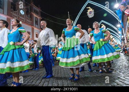 Gli artisti in costume ballano lungo la Rua da se durante un tradizionale marcha al festival di Sanjoaninas, 23 giugno 2022 ad Angra do Heroísmo, Isola di Terceira, Azzorre, Portogallo. Il festival segna il giorno di San Giovanni ed è celebrato con parate, corride e attività culturali. Foto Stock