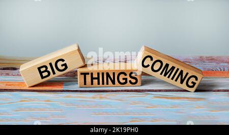 GRANDI COSE CHE ARRIVANO testo su blocchi di legno e sfondo vintage Foto Stock