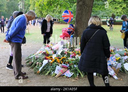 Fiori e carte lasciati intorno agli alberi da ben-wishers dopo la morte della regina Elisabetta II, a Green Park nel centro di Londra, Regno Unito Foto Stock