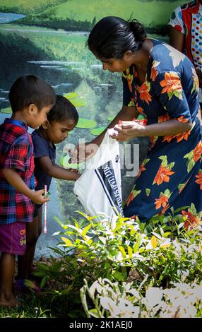Madre che cerca di nutrire i bambini dal cibo ricevuto dalla campagna gratuita in Sri Lanka 30th luglio 2022 Foto Stock