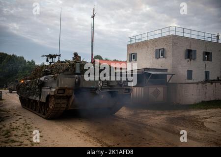 Soldati italiani con 4th reggimento serbatoio, la Brigata Garibaldi avanza attraverso un obiettivo in un serbatoio Ariete C1 mentre conduce un raid accanto ai paracadutisti dell'esercito statunitense assegnati a 2nd battaglione, 503rd reggimento di fanteria paracadute al Joint Multinational Readiness Center di Hohenfels, Germania come parte dell'esercizio Saber Junction 22, 16 settembre 2022. Saber Junction 22 è un esercizio di rotazione multinazionale progettato per valutare la disponibilità della Brigata aerea dell'esercito degli Stati Uniti del 173rd ad eseguire operazioni terrestri unificate in un ambiente congiunto e combinato e per promuovere l'interoperabilità con più di 4,5 Foto Stock