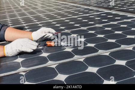 Tecnico che controlla e pulisce i vecchi pannelli solari Foto Stock