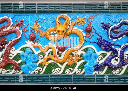 Drago giallo su sfondo blu, ceramica. Nine-Dragon Wall al Giardino dell'amicizia, San Pietroburgo, Russia. Questa è una copia del muro di Shanghai. Foto Stock