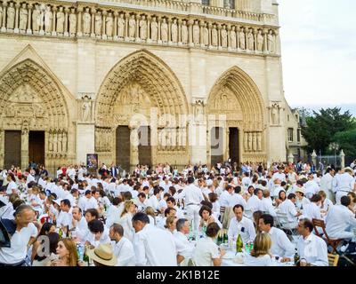 Parigi, Francia. 16 giu 2005 - centinaia di persone si riuniscono come una grande folla per il XVII 'Diner en Blanc' (la cena in bianco), al di fuori della cattedrale di Notre Dame. Gli ospiti invitati a sapere quando la cena sarà, ma non la posizione, che è rivelato solo il giorno dell'evento. Il suo scopo è quello di raccogliere fondi per la ricerca sul cancro di beneficenza. Foto Stock