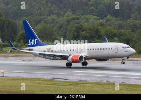 Un aereo di linea Boeing 737-800 di SAS Scandinavian Airlines che atterra su una pista bagnata a Kristiansand in Norvegia Foto Stock