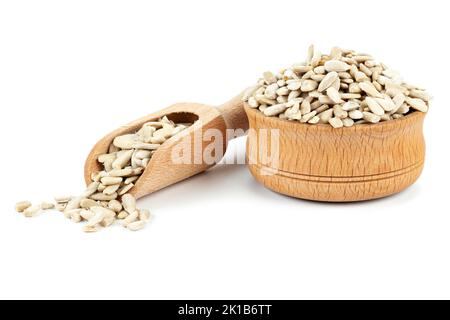 Semi di girasole sbucciati in una ciotola di legno isolata su fondo bianco, rinfrescare i semi di girasole sbucciati in un cucchiaio di legno. Snack da mangiare tra i pasti. Foto Stock