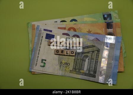 la parola tedesca per un pagamento vacatiob con mattoni e banconote in euro Foto Stock