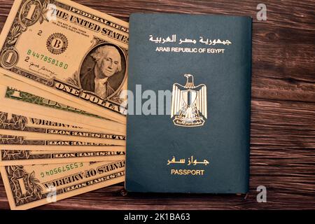 Passaporto egiziano con dollari americani di 1 $ uno banconote in denaro degli Stati Uniti isolato su sfondo di legno, Repubblica araba d'Egitto passaporto con Foto Stock