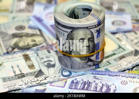 Rotolo di denaro americano con una banda su un mucchio di banconote in dollari americani banconote in contanti americani con Arabia Saudita riyals banconote in denaro e New Emir Foto Stock