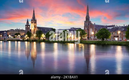 La vista delle chiese di Inverness sul fiume Ness, Scozia, Regno Unito all'alba drammatica con riflessi nell'acqua Foto Stock